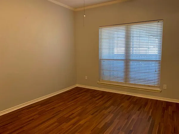 a view of a room that has wooden floor and a window