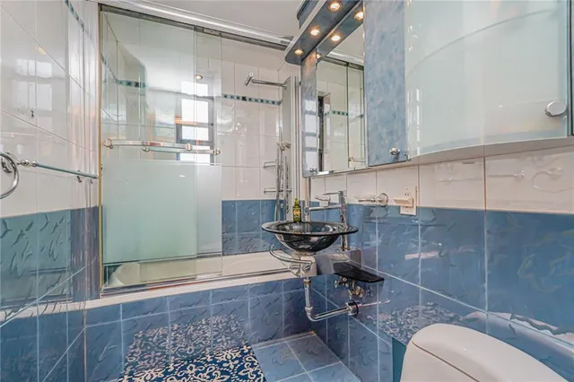 a bathroom with a sink a toilet and shower