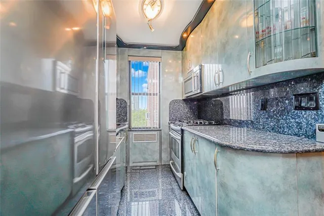 a kitchen with stainless steel appliances granite countertop a refrigerator a sink and a stove