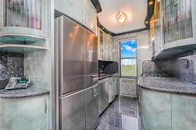 a kitchen with stainless steel appliances granite countertop a refrigerator and a sink