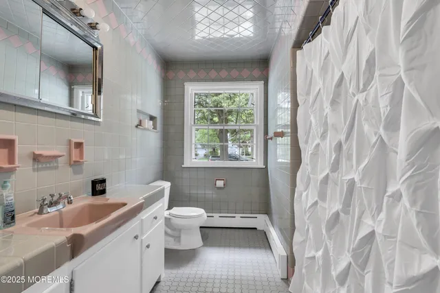 a bathroom with a sink a toilet and a window