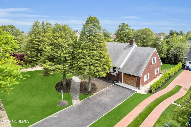a aerial view of a house with a yard table and chairs
