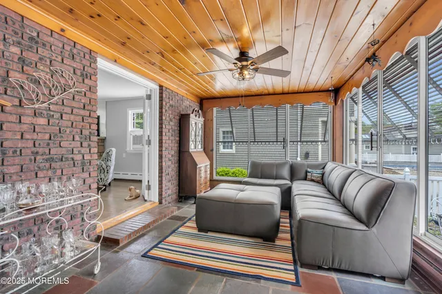 a living room with furniture a chandelier and a floor to ceiling window