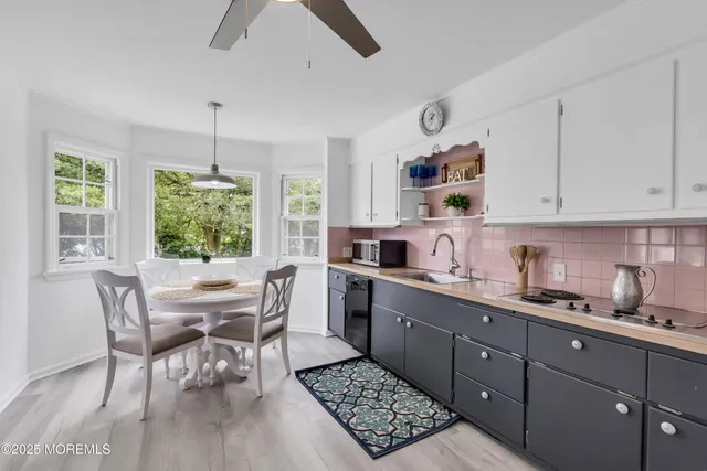 a kitchen with stainless steel appliances granite countertop a stove a sink dishwasher a dining table and chairs with wooden floor