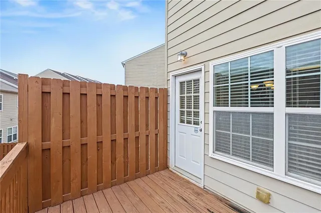 a view of a balcony with wooden floor and fence