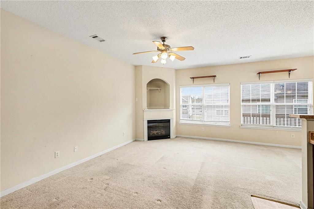 7676 Rutgers Circle Fairburn, GA 30213 - Photo 7 of 33 an empty room with windows and fireplace