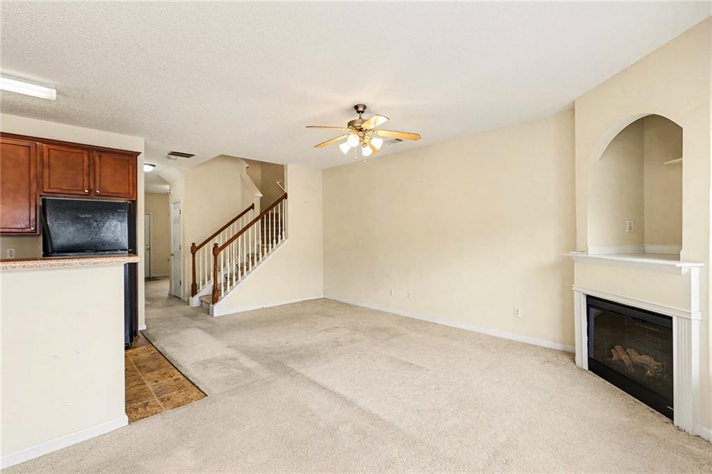 7676 Rutgers Circle Fairburn, GA 30213 - Photo 9 of 33 a view of an empty room with chandelier fan and fire place