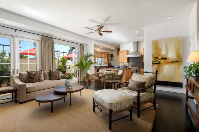 a living room with furniture kitchen view and a large window