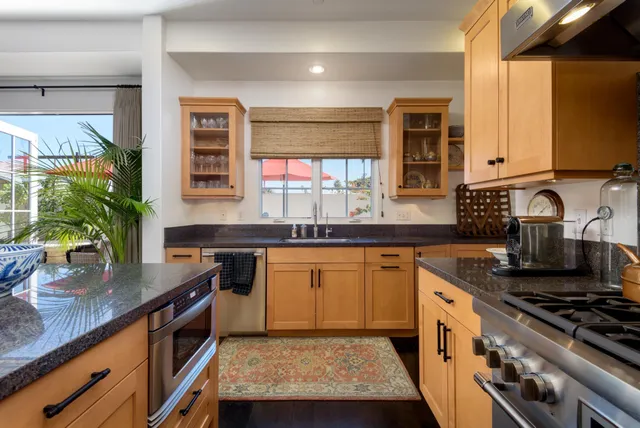 a kitchen with stainless steel appliances granite countertop sink stove and cabinets