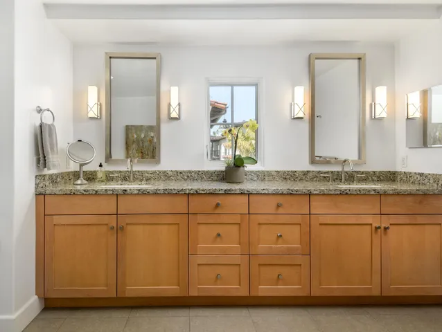 a bathroom with a granite countertop sink and a mirror