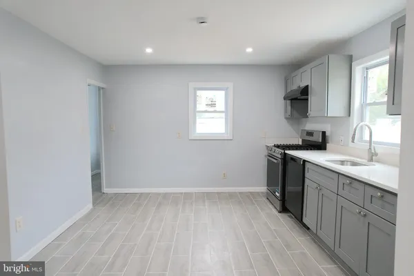 a view of a kitchen with sink and dishwasher wooden floor