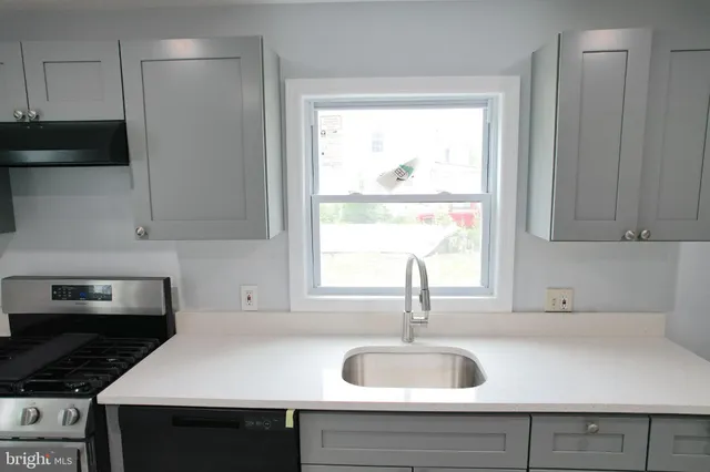 a kitchen with granite countertop a sink and a stove