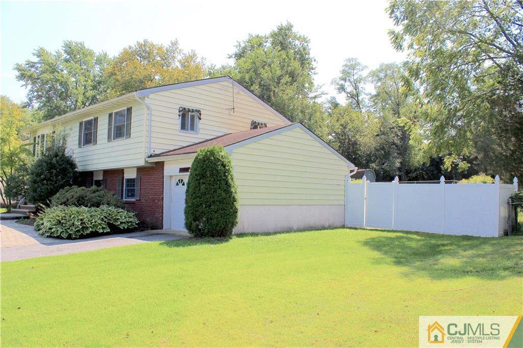 33 Andover Road Jackson, NJ 08527 - Photo 3 of 25 a view of a white house with a small yard and a large tree