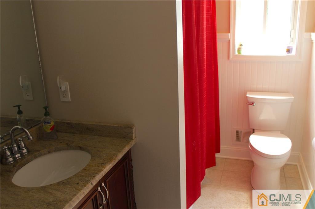 33 Andover Road Jackson, NJ 08527 - Photo 9 of 25 a bathroom with a granite countertop sink and a toilet