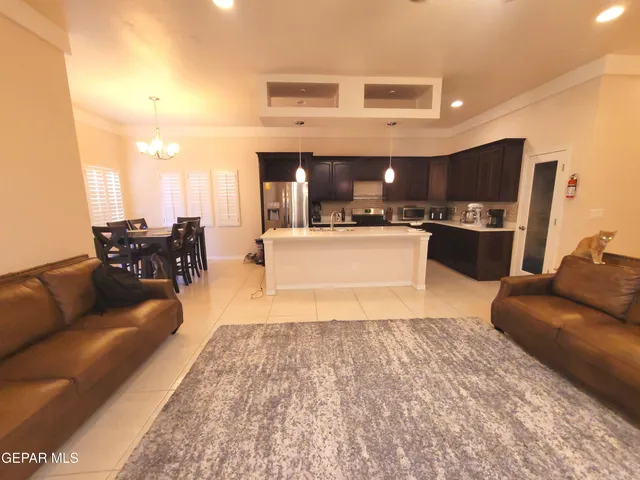 a large kitchen with kitchen island a counter top space a sink a refrigerator a washer and dryer