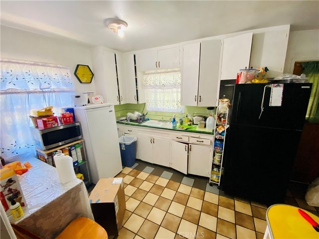 a kitchen with a refrigerator and a stove top oven