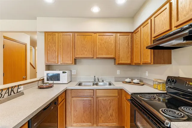 a kitchen with stainless steel appliances granite countertop a sink stove and cabinets