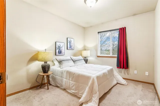 a bedroom with a bed and a painting on the wall