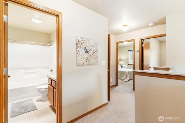 a bathroom with a granite countertop sink a toilet and a large mirror
