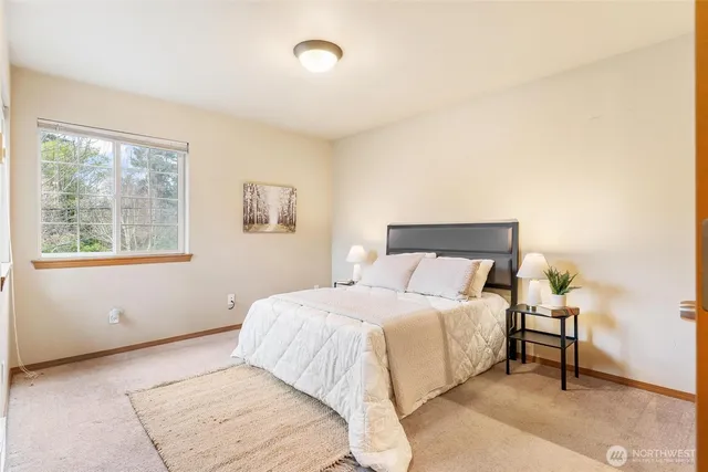 a bedroom with a bed and a large window