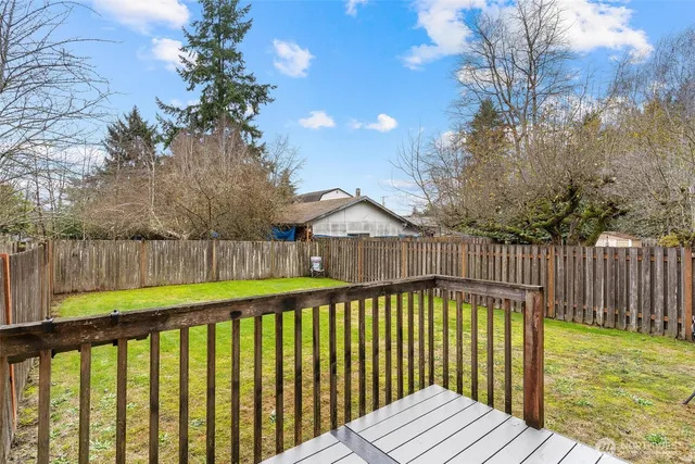 a view of a porch with wooden floor and wooden fence