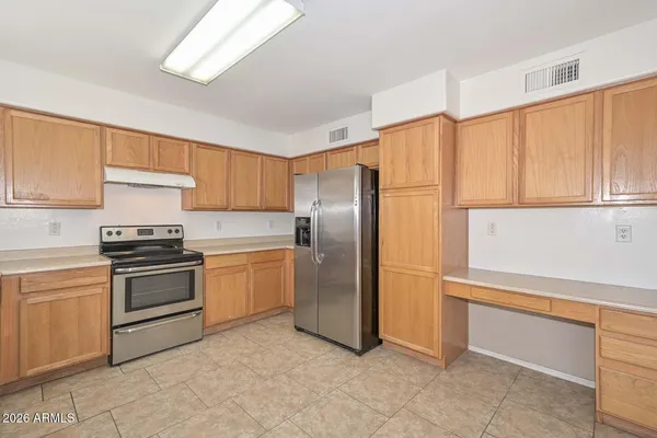 a kitchen with a refrigerator sink and cabinets