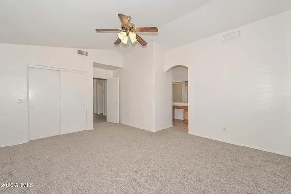 a view of an empty room with a chandelier fan