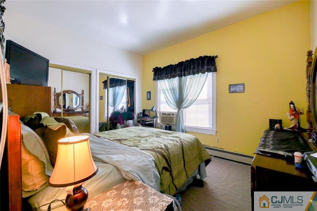 65 Meadow Road Edison, NJ 08817 - Photo 16 of 24 a bedroom with a bed and a large mirror on the dresser