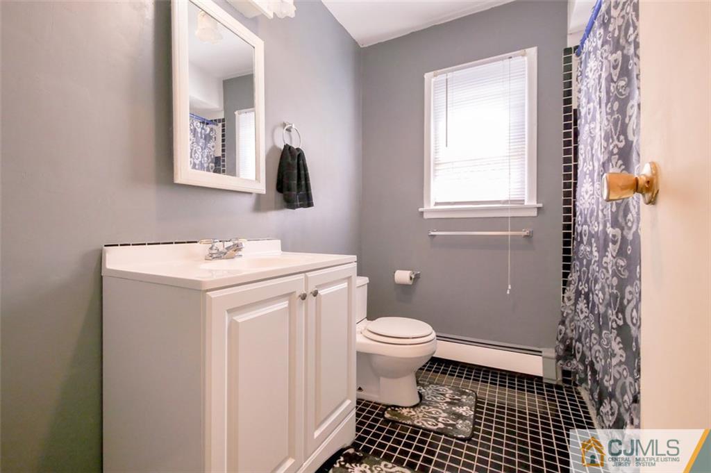65 Meadow Road Edison, NJ 08817 - Photo 20 of 24 a bathroom with a sink toilet a mirror and shower