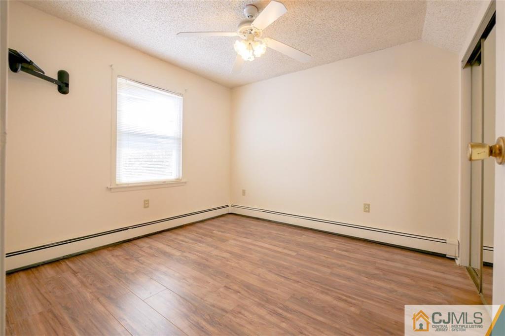 65 Meadow Road Edison, NJ 08817 - Photo 21 of 24 an empty room with wooden floor cabinet and windows