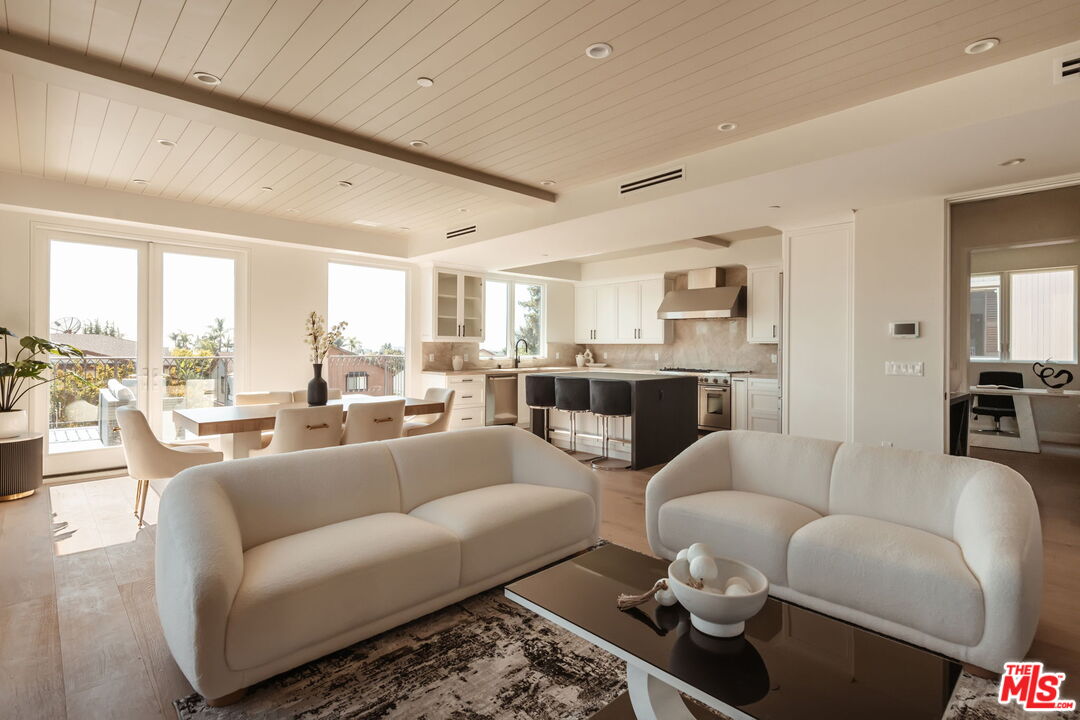a living room with furniture wooden floor and a large window