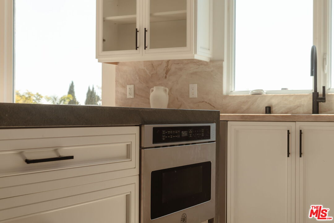 10725 Ashton Avenue, Unit 101 Los Angeles, CA 90024 - Photo 14 of 40 a kitchen with a stove cabinets and a window