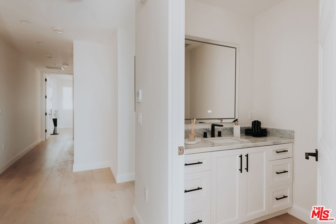 10725 Ashton Avenue, Unit 101 Los Angeles, CA 90024 - Photo 23 of 40 a bathroom with a double vanity sink and mirror