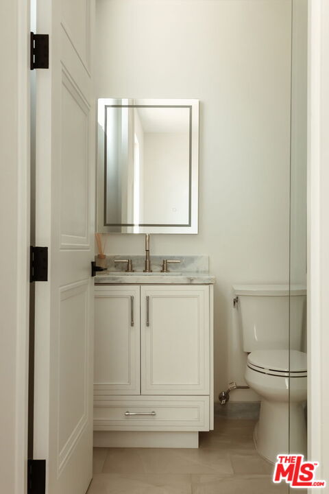 10725 Ashton Avenue, Unit 101 Los Angeles, CA 90024 - Photo 32 of 40 a bathroom with a sink a toilet and a mirror