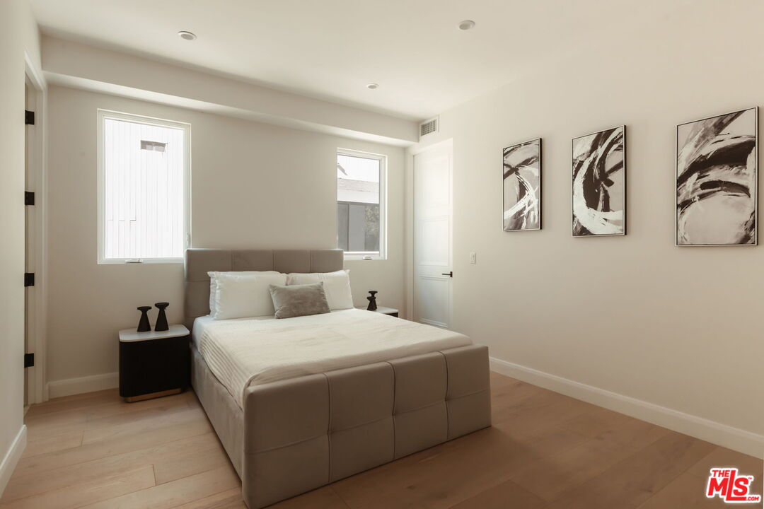 10725 Ashton Avenue, Unit 101 Los Angeles, CA 90024 - Photo 33 of 40 a bedroom with a bed and painting on the wall