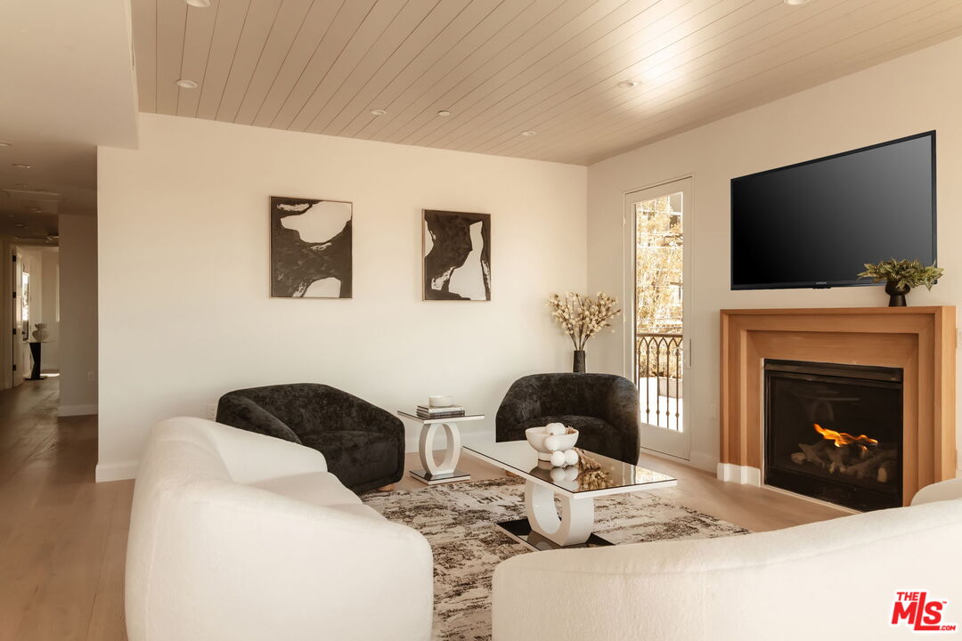 10725 Ashton Avenue, Unit 101 Los Angeles, CA 90024 - Photo 5 of 40 a living room with furniture a flat screen tv and a fireplace
