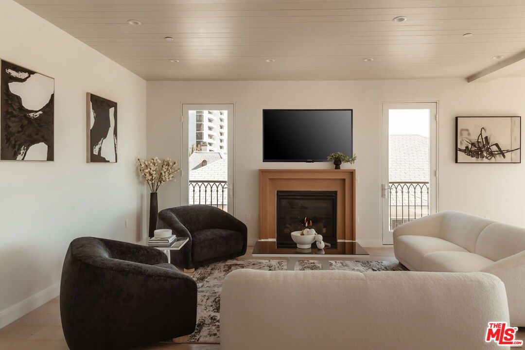 10725 Ashton Avenue, Unit 101 Los Angeles, CA 90024 - Photo 6 of 40 a living room with furniture a fireplace and a flat screen tv