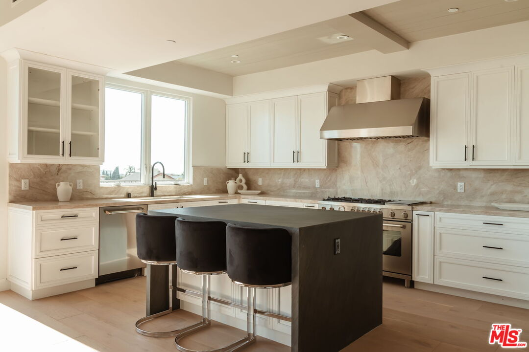 10725 Ashton Avenue, Unit 101 Los Angeles, CA 90024 - Photo 9 of 40 a kitchen with a sink stove and white cabinets