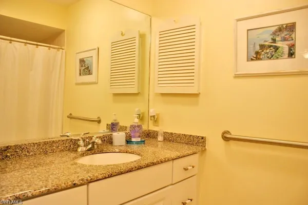 a bathroom with a granite countertop sink and a mirror