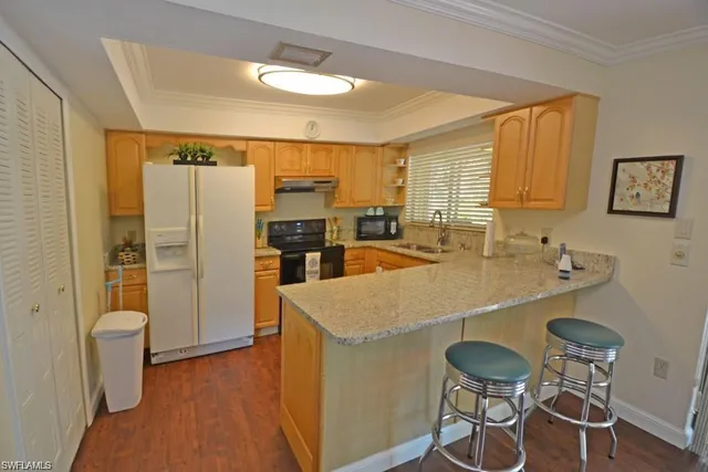 a kitchen with kitchen island a sink stove and refrigerator
