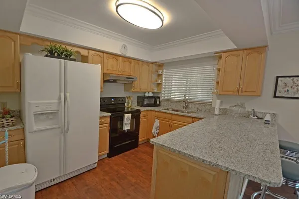 a kitchen with stainless steel appliances granite countertop a refrigerator sink and stove