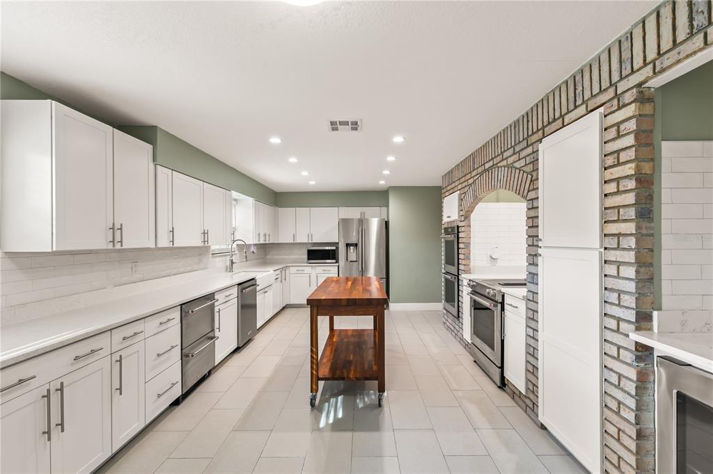 4951 Courtland Loop Winter Springs, FL 32708 - Photo 7 of 36 a kitchen with white cabinets and sink