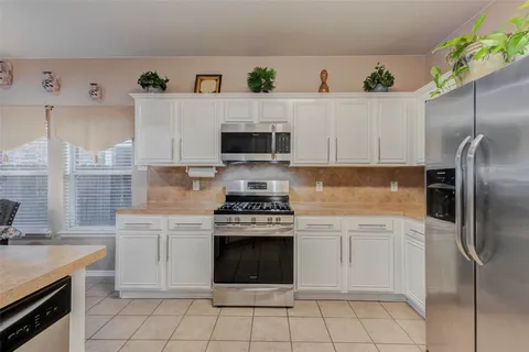 a kitchen with cabinets stainless steel appliances and a sink