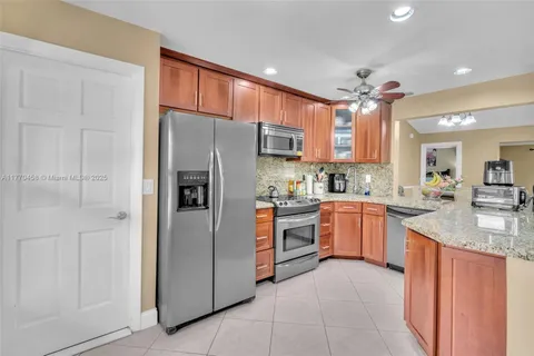 a kitchen with stainless steel appliances granite countertop a refrigerator and a sink