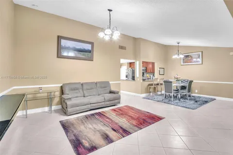a living room with furniture a chandelier and a dining table