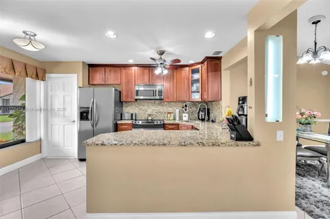 a kitchen with stainless steel appliances granite countertop a refrigerator and a sink