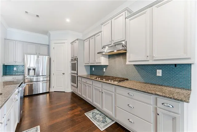 a kitchen with stainless steel appliances granite countertop a refrigerator sink and cabinets