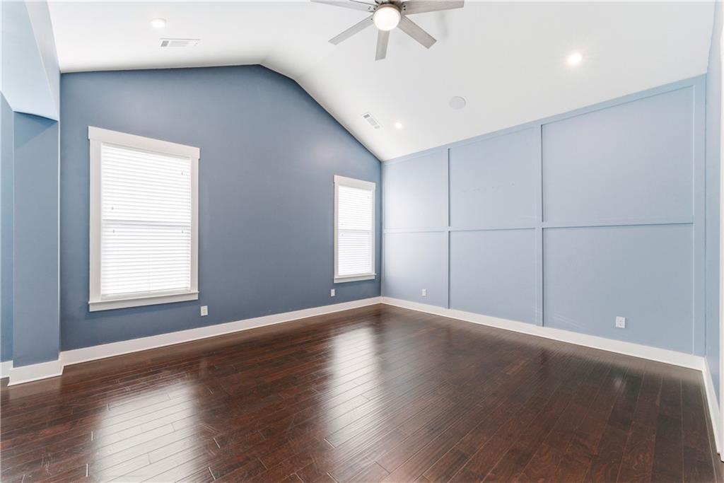 601 Long Leaf Way Canton, GA 30114 - Photo 19 of 42 an empty room with wooden floor chandelier fan and windows