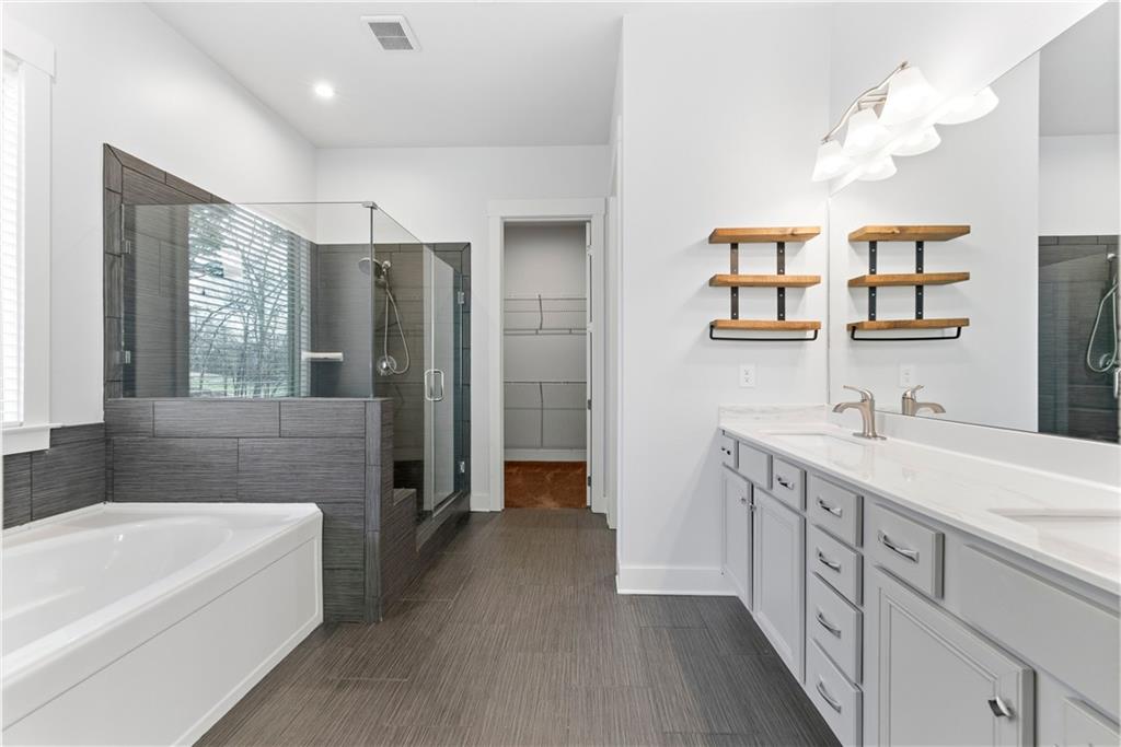 601 Long Leaf Way Canton, GA 30114 - Photo 22 of 42 a bathroom with a tub a sink and a mirror