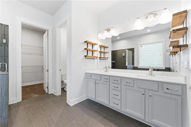 a spacious bathroom with a double vanity sink a mirror and a shower